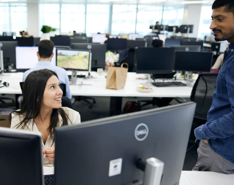 woman chatting to a man at an office desk