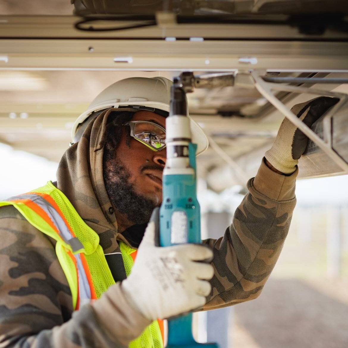 A man in protective gear builds a solar panel