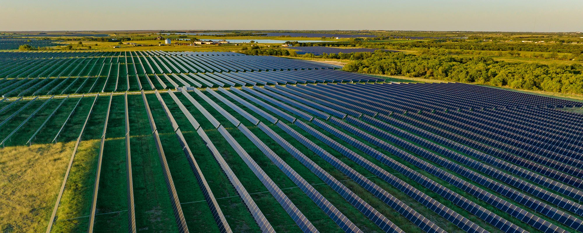 Aerial view of the Lightsource bp Briar Creek Texas solar project, part of their US Projects portfolio, with rows of panels stretching across green fields under a clear sky.