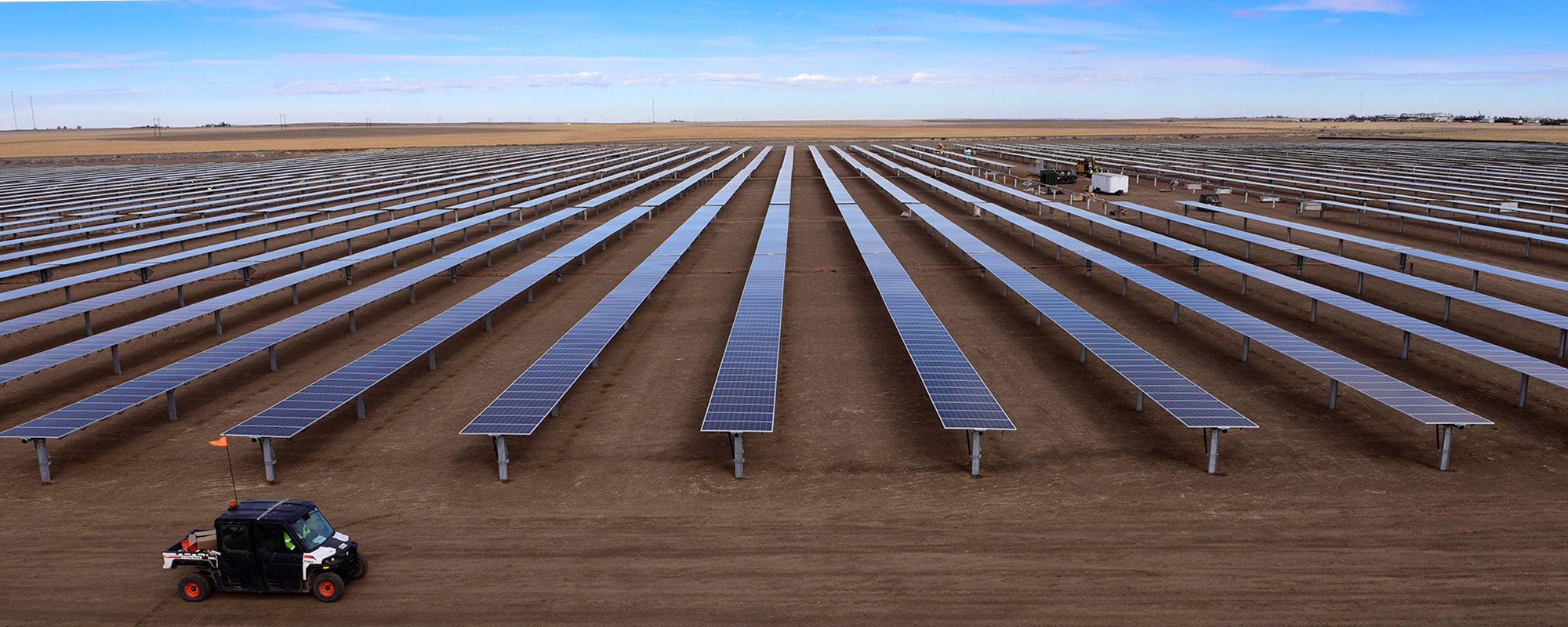 rial view of the Lightsource bp Johnson Corner solar project in Kansas, part of their US Projects portfolio, rows of panels stretch across vast, flat land with a utility vehicle on site.