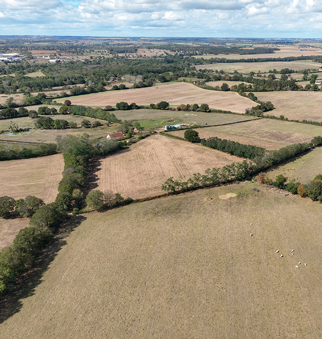 Overhead shot of rolling hills and fields in a rural farming region.
