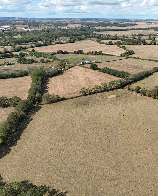 Overhead shot of rolling hills and fields in a rural farming region.