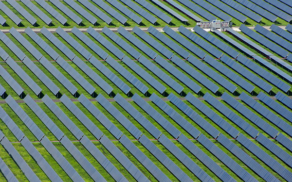 Aerial view of the Lightsource bp Second Division Solar project in Texas, part of their US Projects portfolio, rows of panels stretch across green fields in precise diagonal lines.