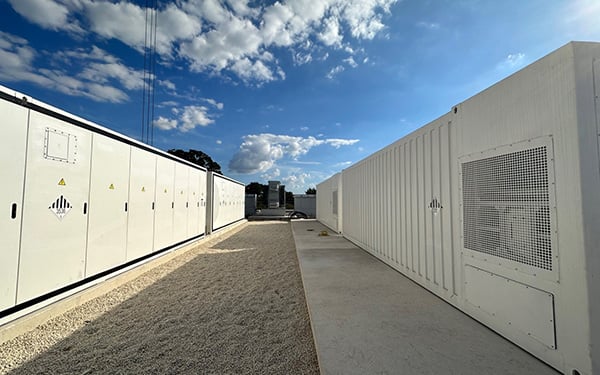 Outdoor view of a utility-scale battery energy storage system (BESS) composed of large white containers