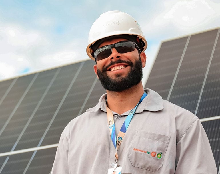 Lightsource bp solar farm worker smiling with a blurred background of solar panels