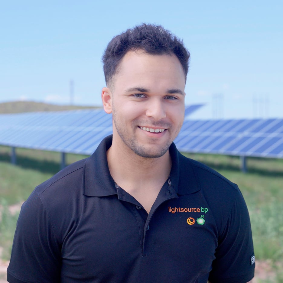 Man wearing a lightsource bp polo t-shirt standing in a field of solar panels
