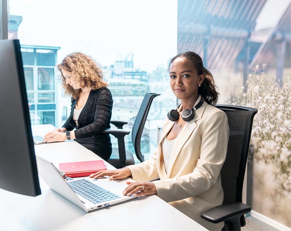 Two female office workers working by their desks