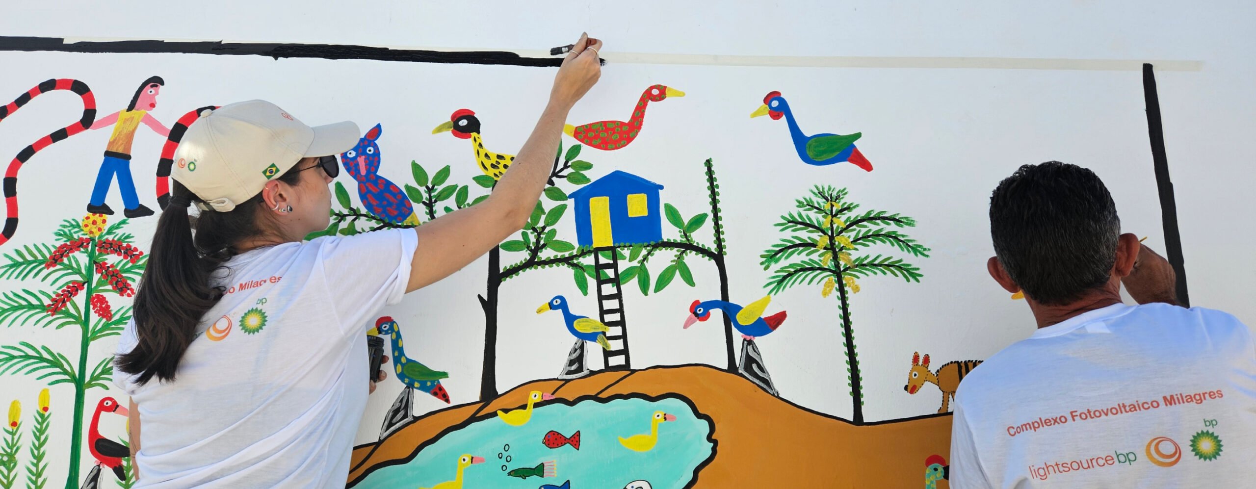 Two people painting a mural