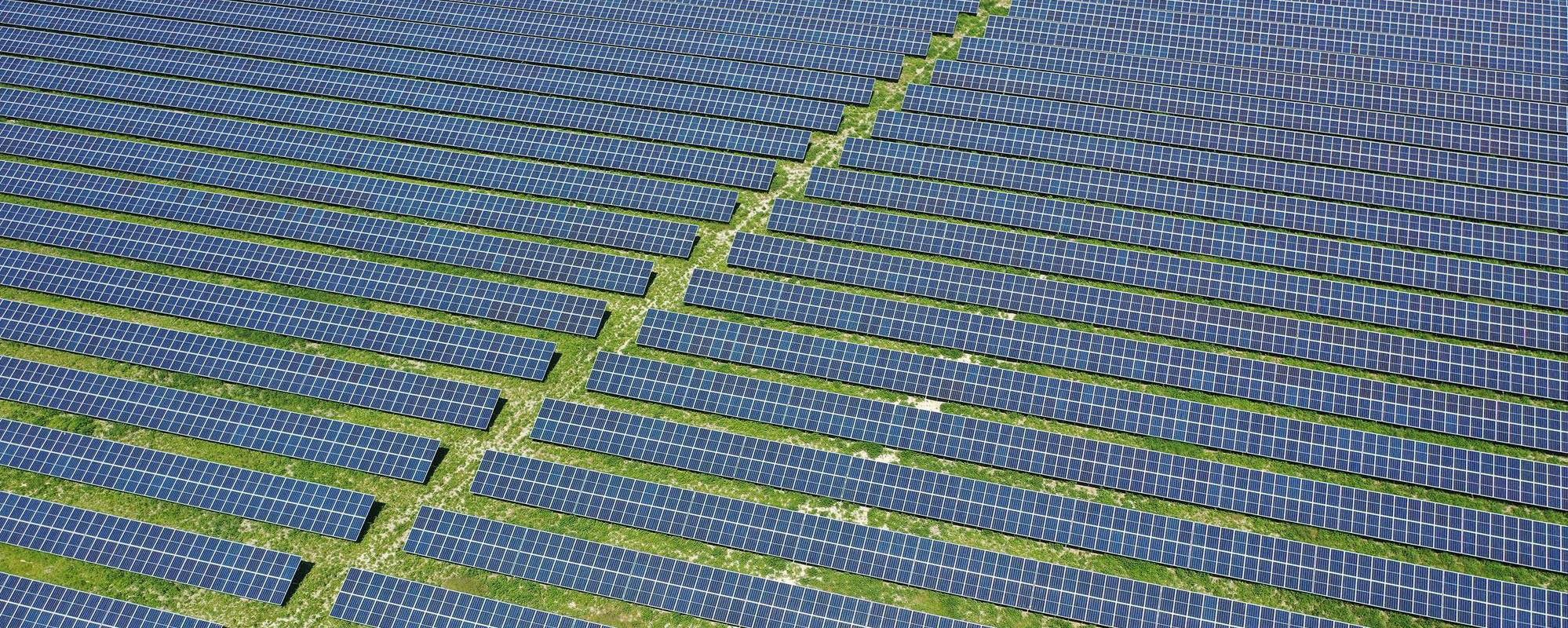 Aerial shot of a solar farm, the panels displaying diagonally