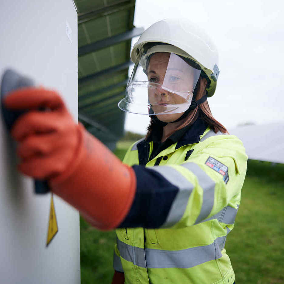 Engineer on site on a solar farm in full PPE