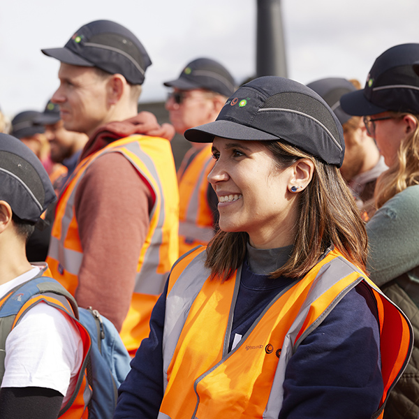 Isabel Gil Pereira in hi vis and bump cap PPE on a team solar farm site visit