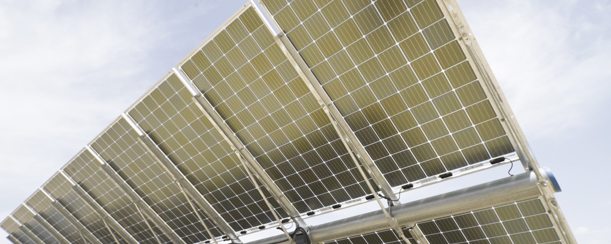 Close-up of solar panels at a Lightsource bp solar project, showing the grid pattern and metal framing under bright daylight.