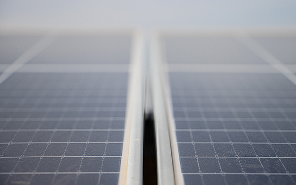 Close-up of two solar panels at a Lightsource bp solar project, showing the grid pattern and metal framing under soft, even lighting.