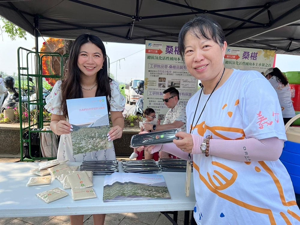 Vivi Lee at a community event holding Lightsource bp branded items and a brochure