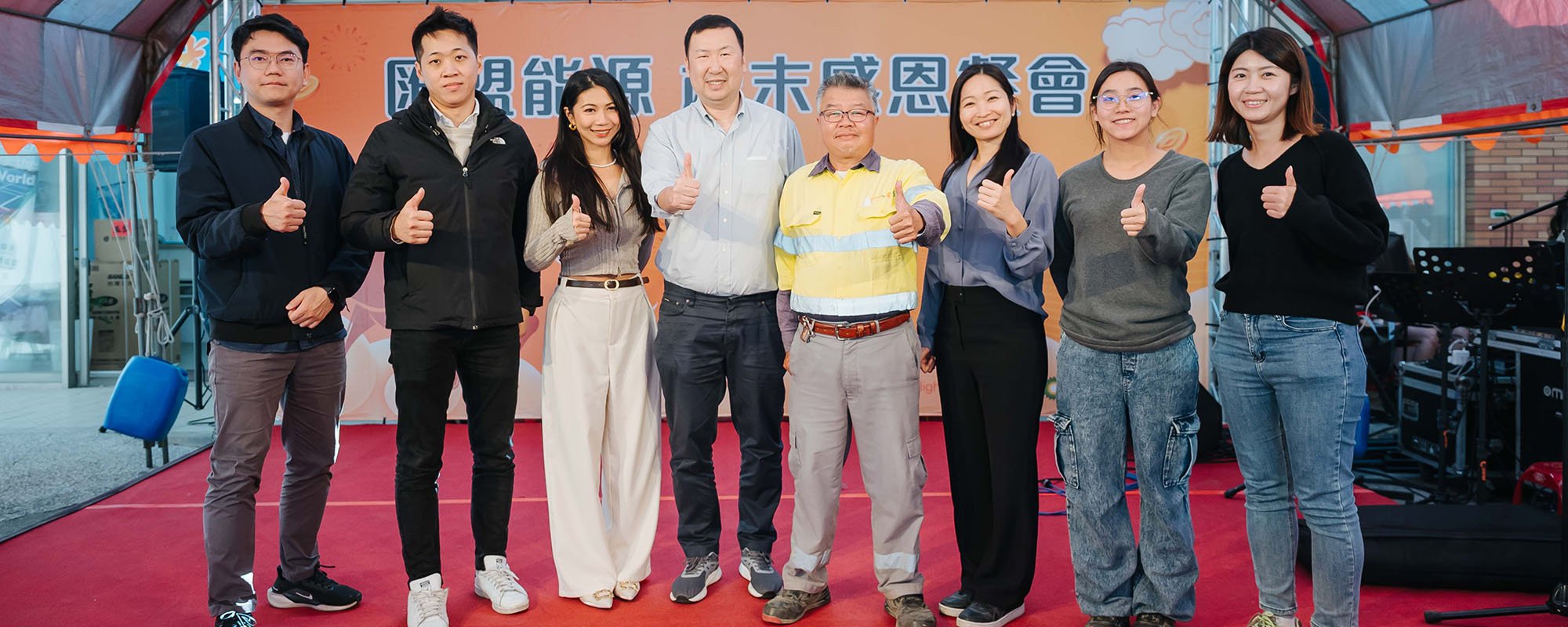 Group shot of people, the Lightsource bp team, on stage at a community event in Taiwan