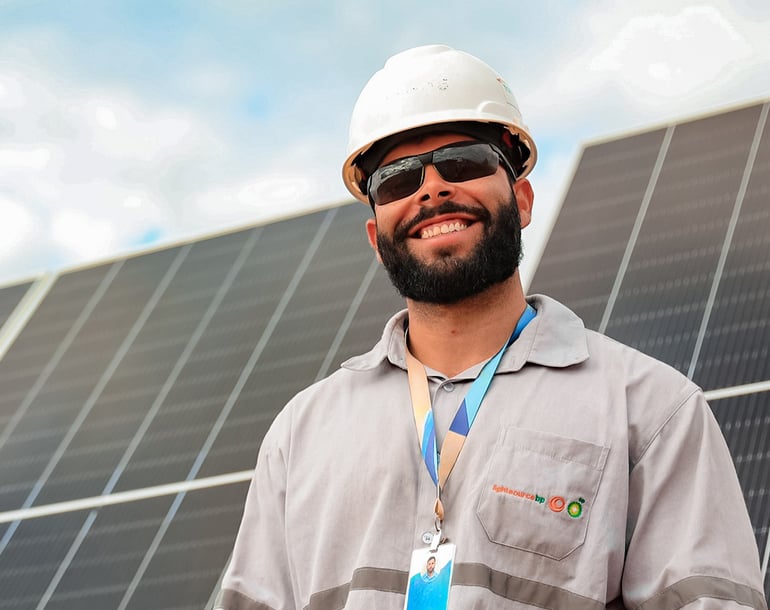 Lightsource bp solar farm worker smiling with a blurred background of solar panels